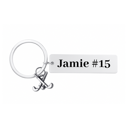 Stainless steel field hockey bar keychain engraved with name and stick charm on white background
