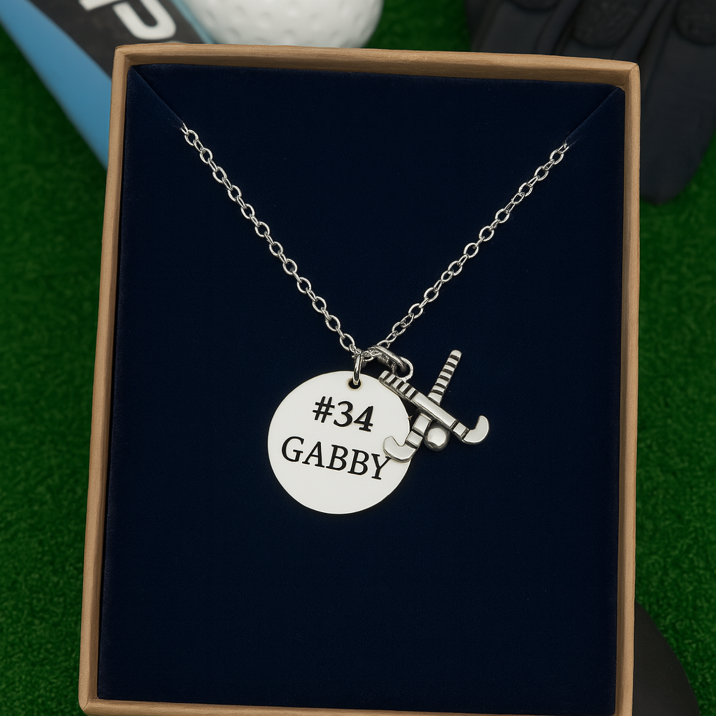 Field hockey necklace gift set with charm and personalized name pendant on black background
