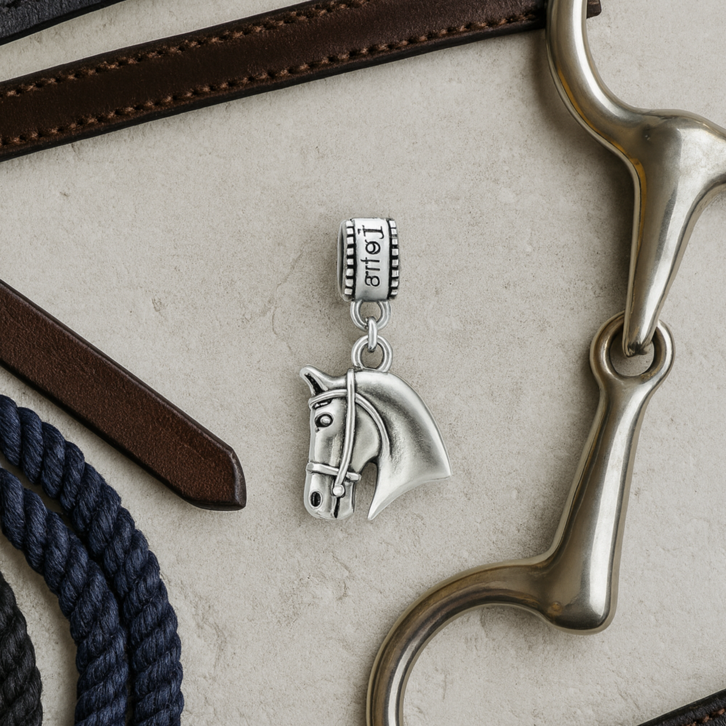 Horse head charm bead with 'Love' detail displayed on elegant jewelry dish
