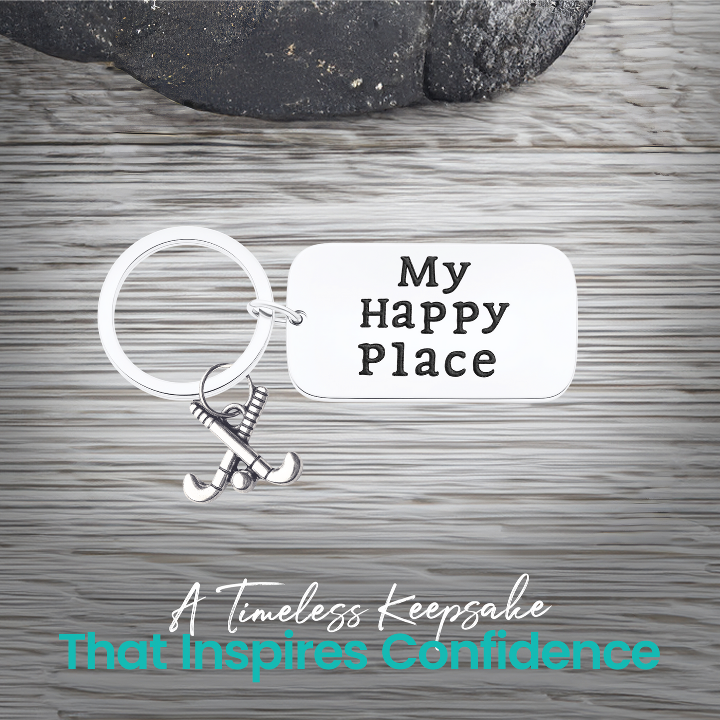 Close-up of field hockey keychain with My Happy Place engraving on rustic wood background