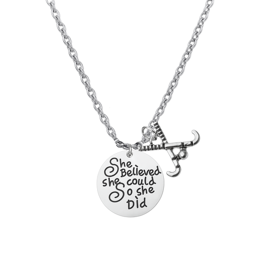 Silver field hockey necklace with crossed sticks charm and engraved She Believed She Could So She Did pendant on 18-inch chain