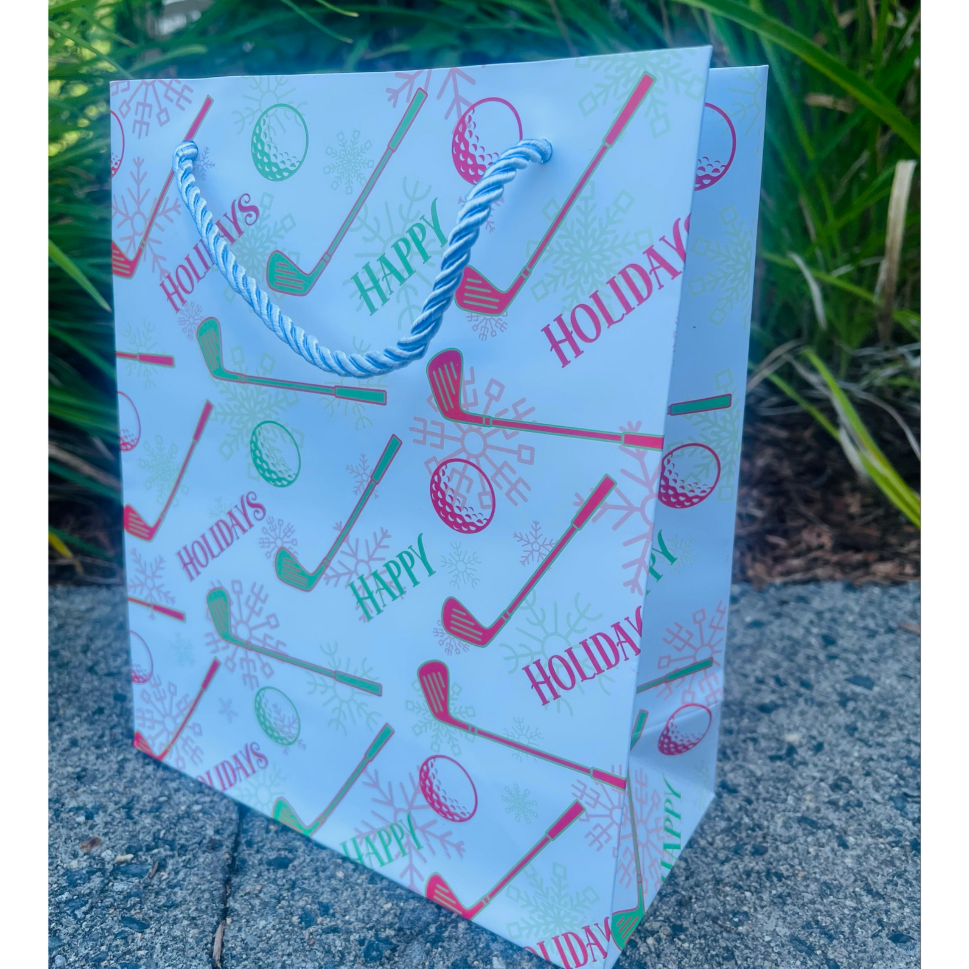 Golf holiday gift bag featuring red and green golf clubs and balls, perfect for golf lovers this season.