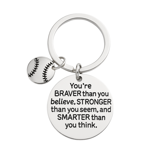 Silver softball keychain with engraved quote: “You’re Braver Than You Believe, Stronger Than You Seem, and Smarter Than You Think”