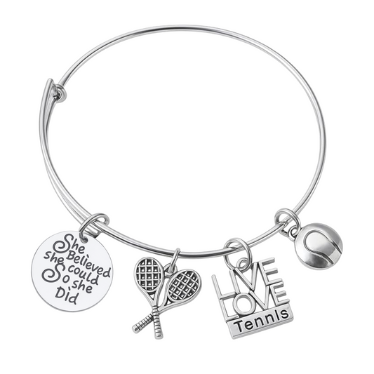 Tennis charm bangle bracelet with silver-tone charms including "She Believed She Could So She Did," tennis racket, and LOVE