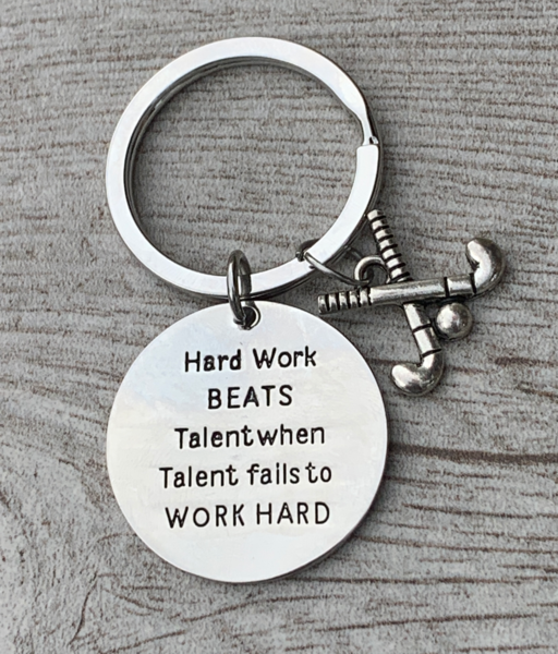 Work Hard Beats Talent field hockey keychain displayed next to white field hockey ball