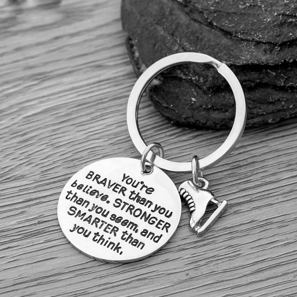 You’re Braver than You Believe figure skating keychain with ice skate charm on rustic wood background