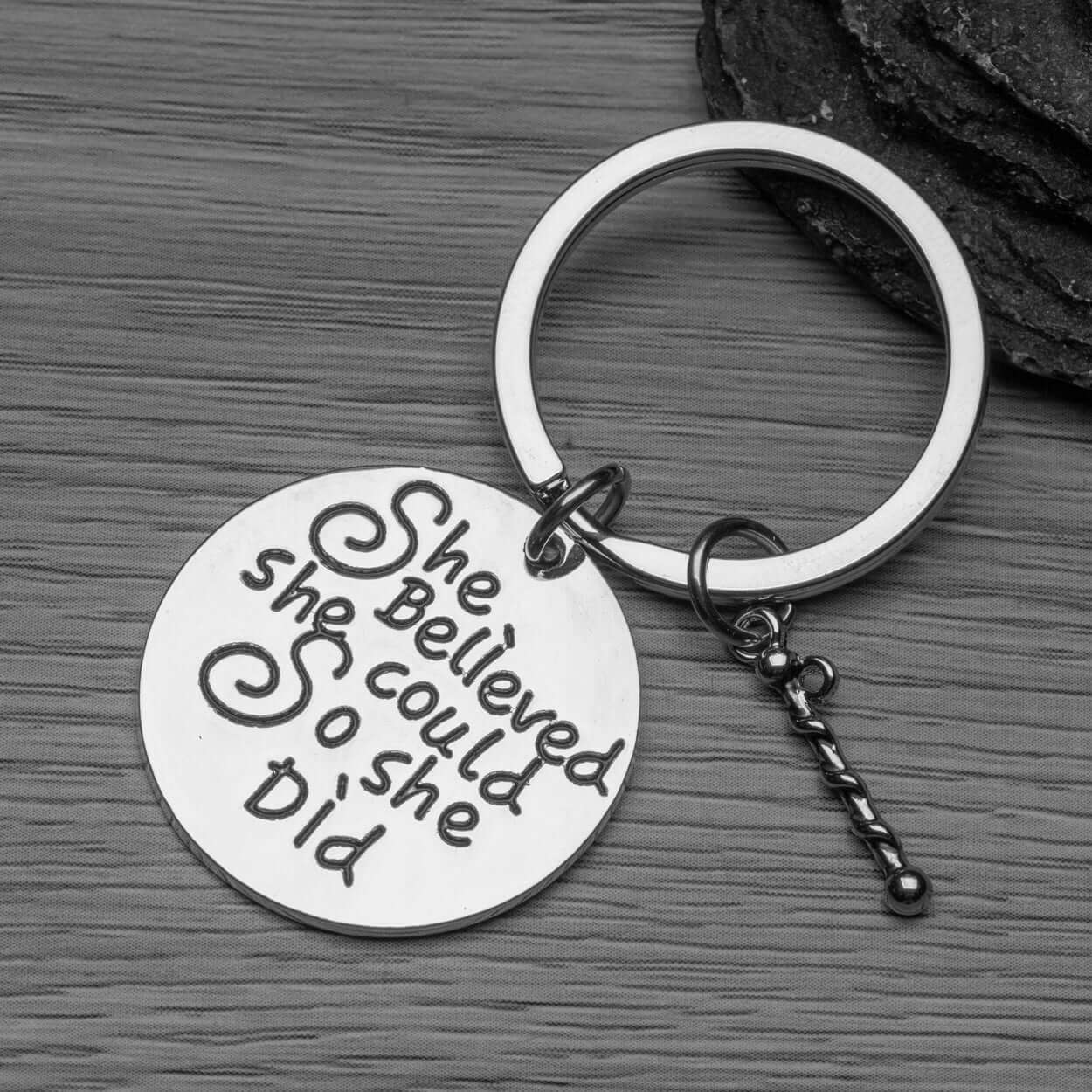 Twirling keychain with motivational quote displayed on a dark background for a stylish gift look