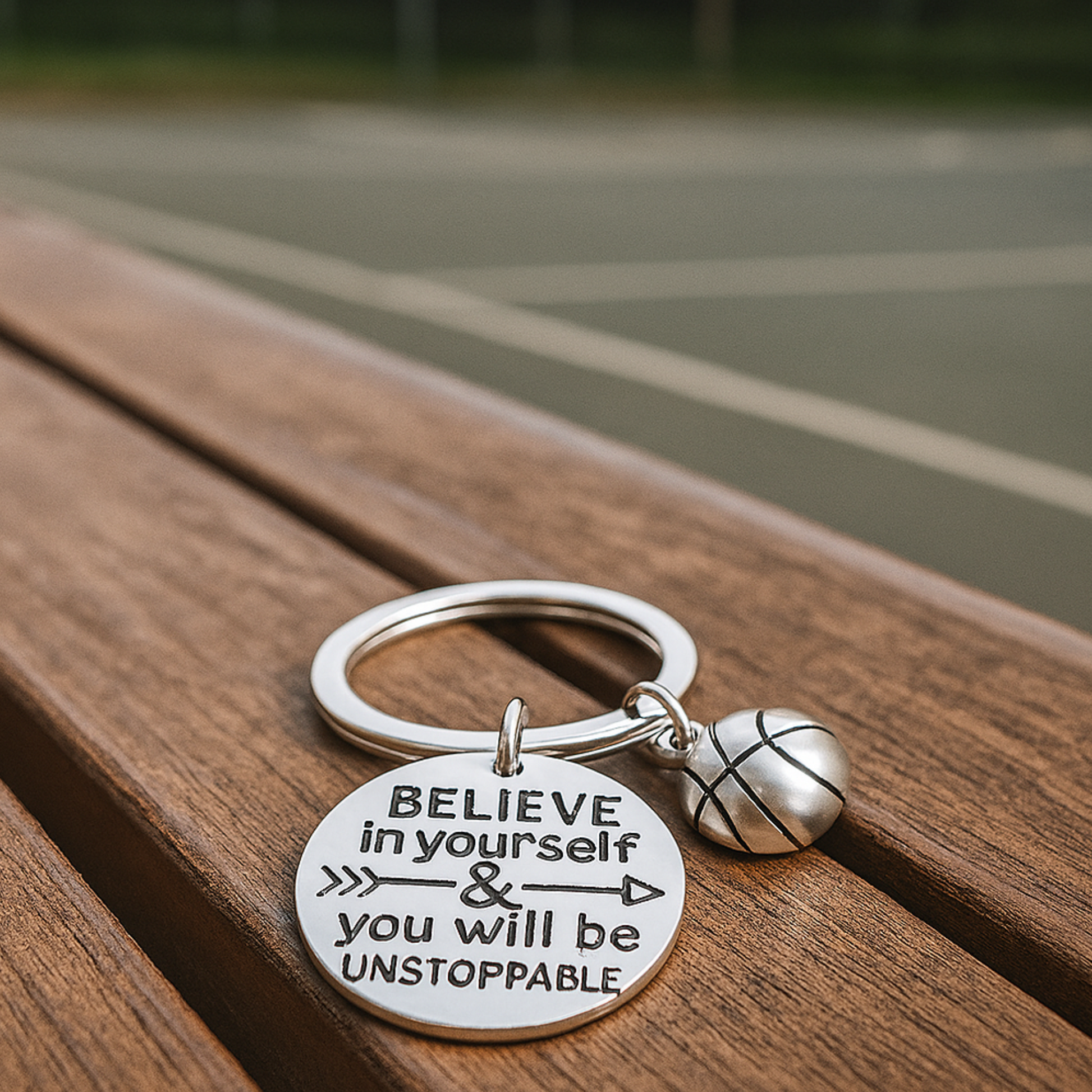 Flat-lay image of basketball keychain with engraved quote on wood background