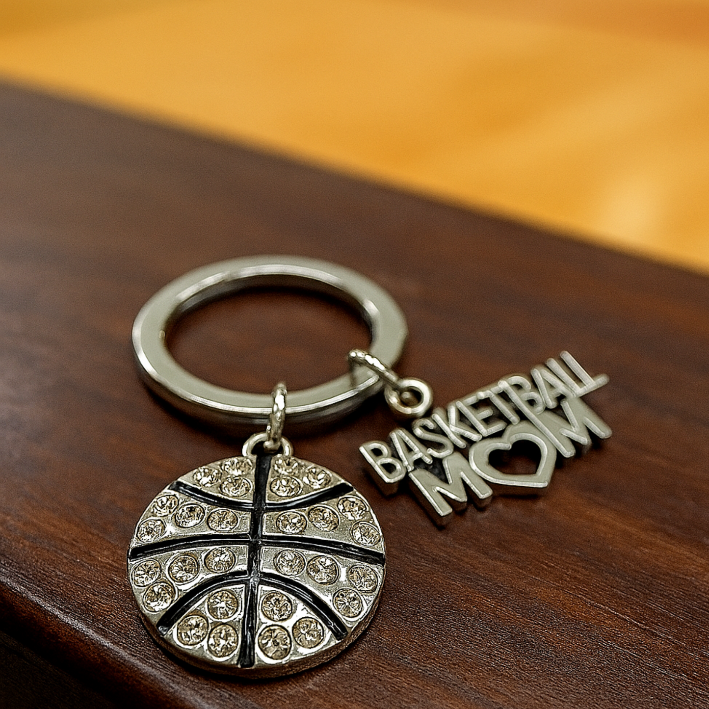 Close-up of silver Basketball Mom keychain resting on wood surface, perfect for gifting