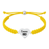 Yellow bracelet with heart charm engraved “XC.”