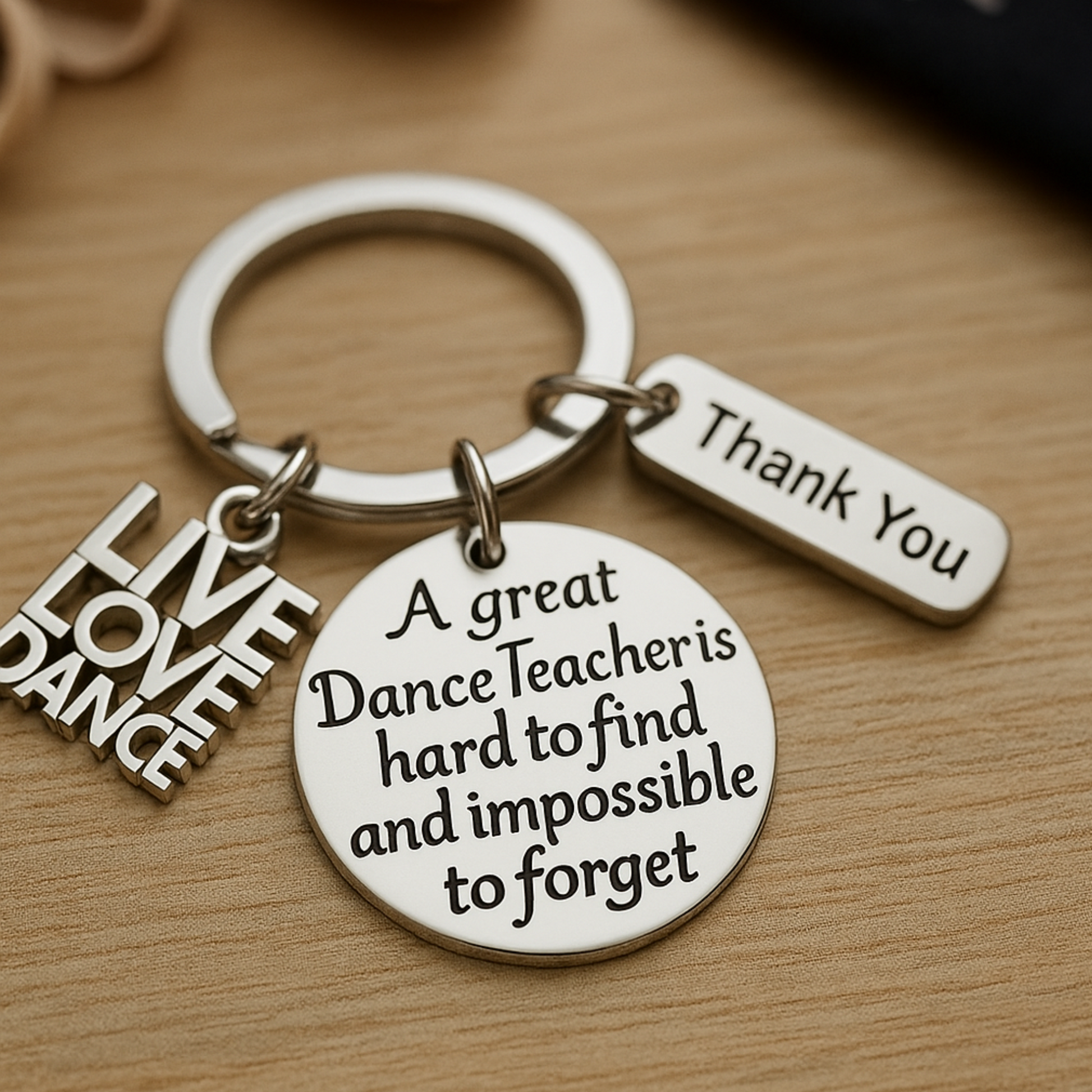 Close-up of engraved dance teacher keychain on wood surface, ideal gift for instructors