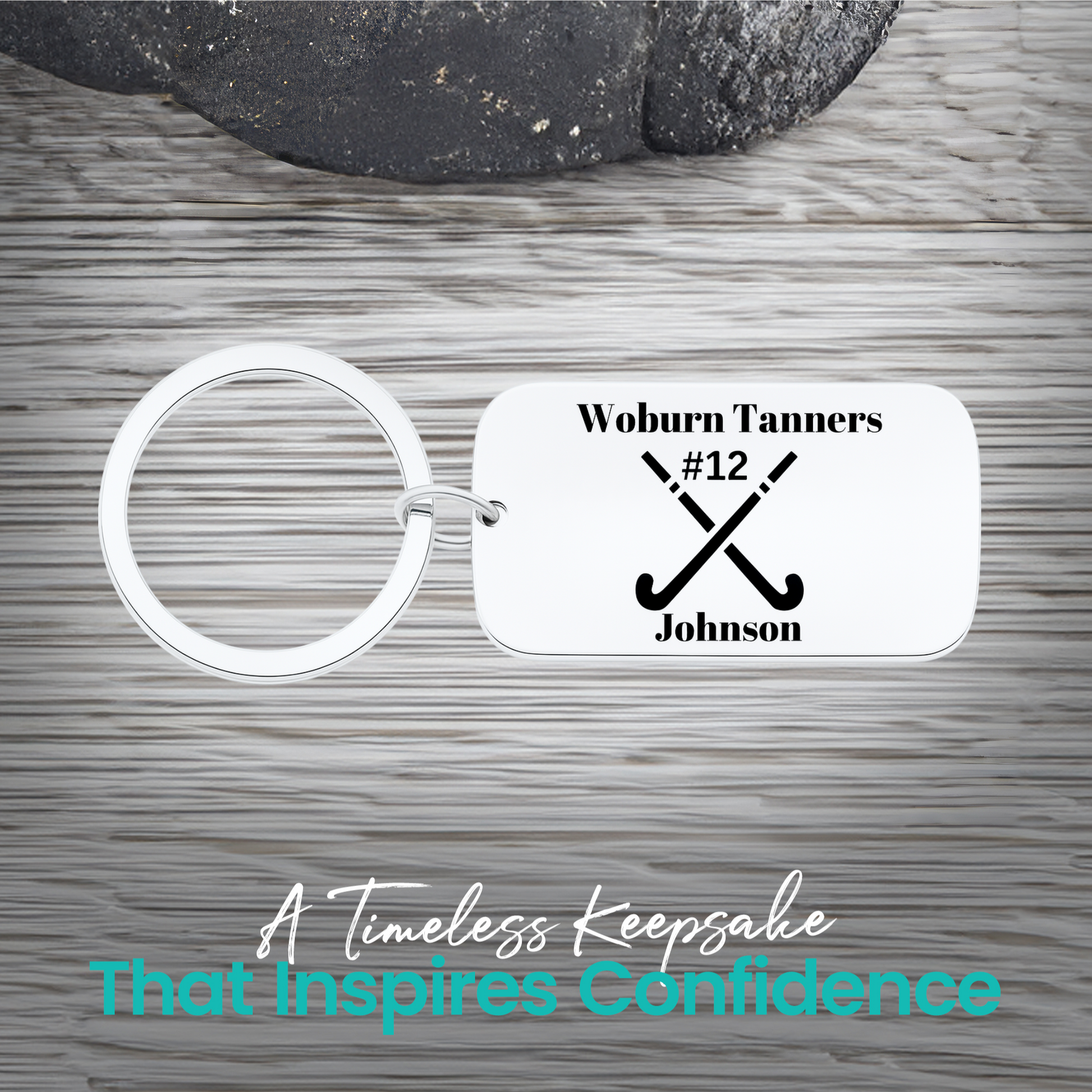 Stainless steel field hockey dog tag keychain with crossed sticks and personalized engraving on rustic wood