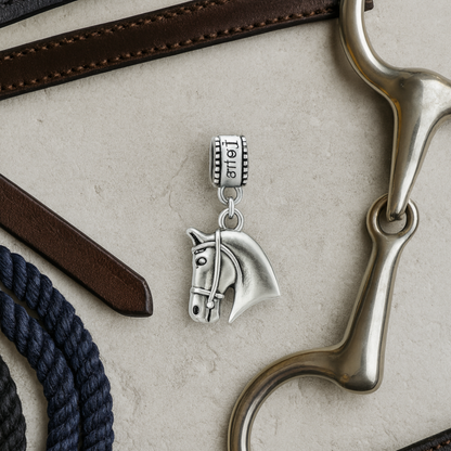 Horse head charm bead with 'Love' detail displayed on elegant jewelry dish