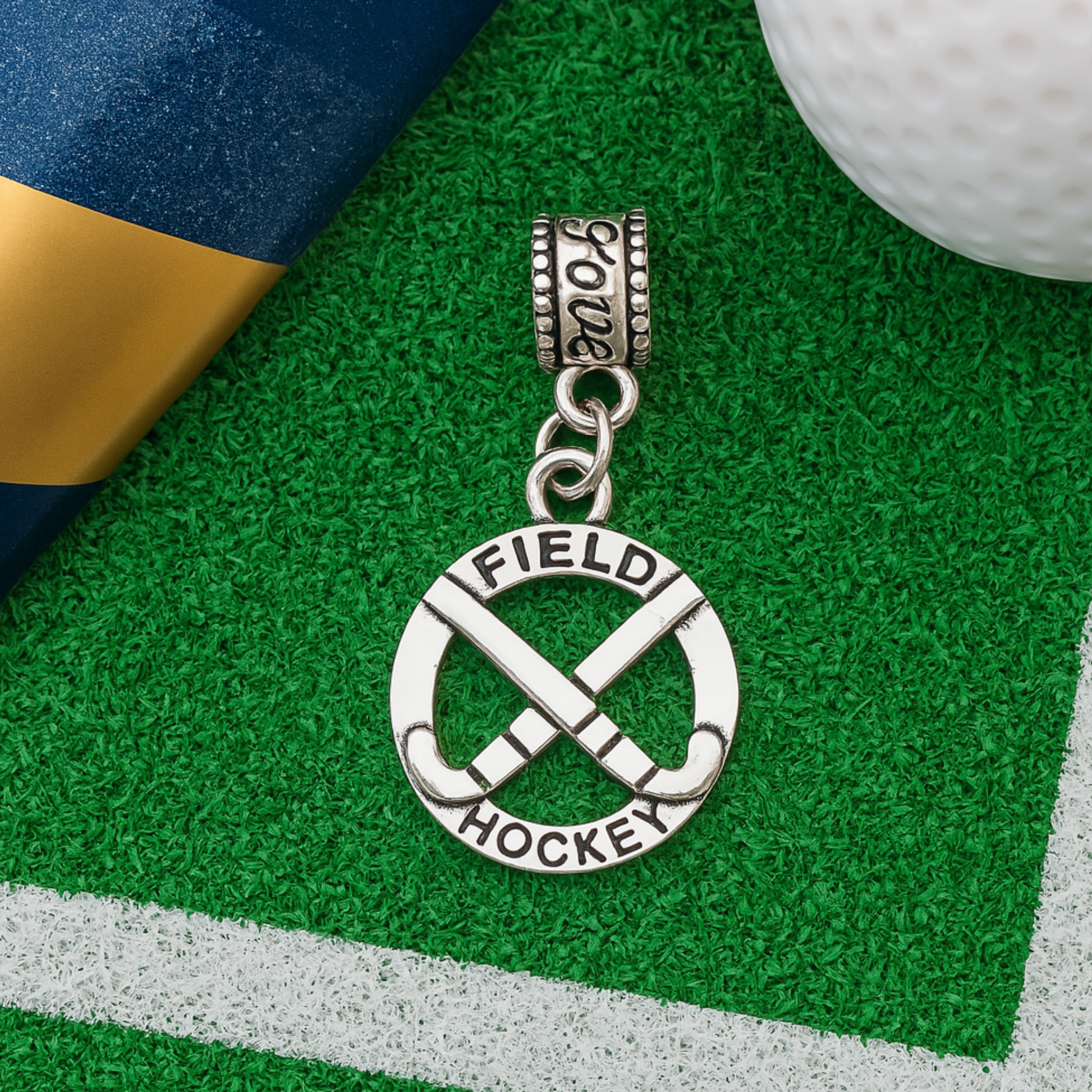 Silver field hockey charm bead with crossed sticks and laurel wreath design