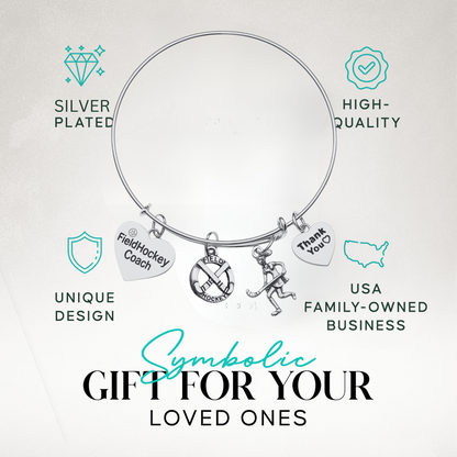 Adjustable silver coach bangle bracelet with engraved charms shown on turquoise background with product features