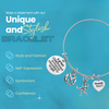 Adjustable silver coach bangle bracelet with engraved charms shown on turquoise background with product features