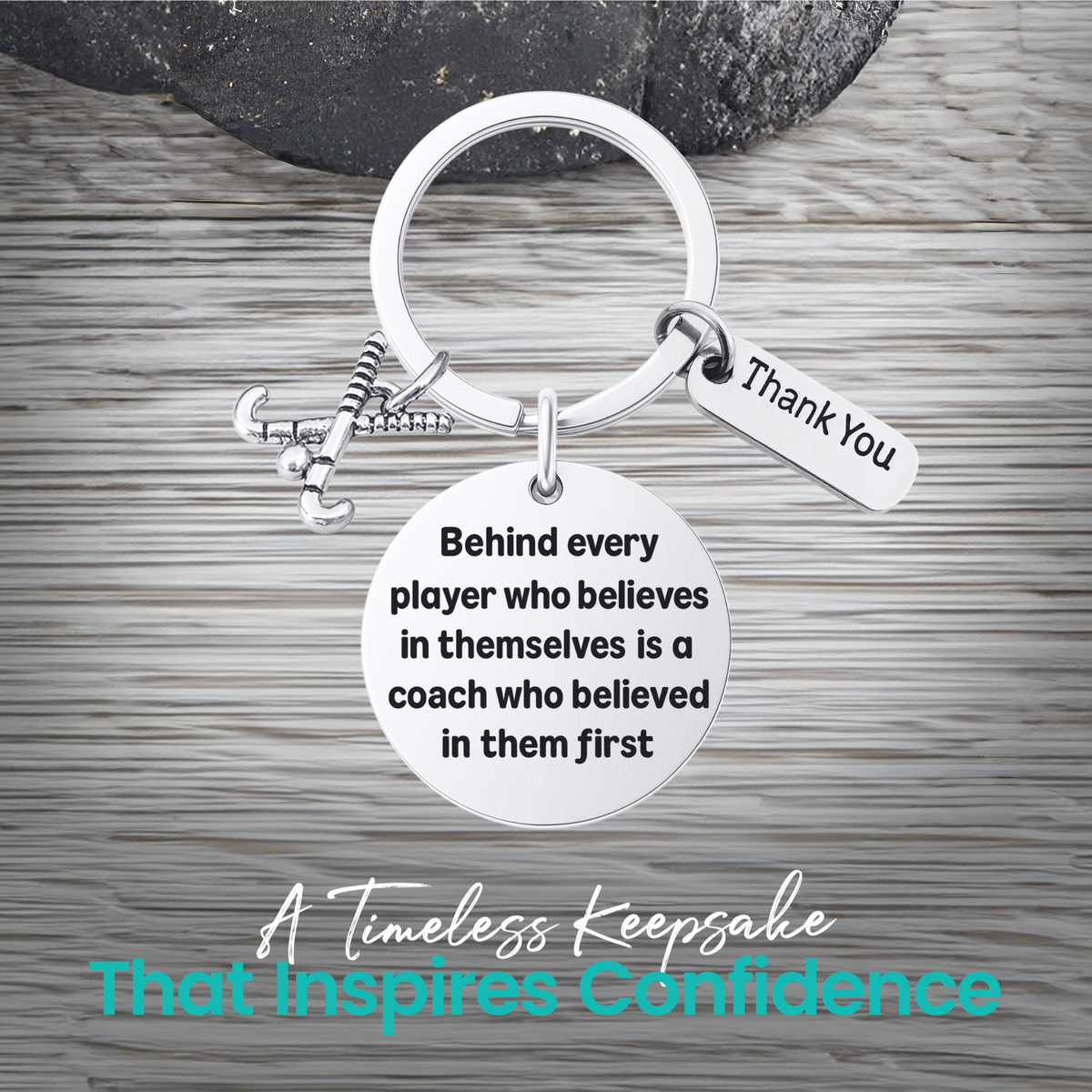 Silver field hockey coach keychain with inspirational Behind Every Player engraving on rustic wood