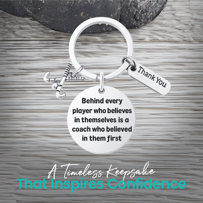 Silver field hockey coach keychain with inspirational Behind Every Player engraving on rustic wood
