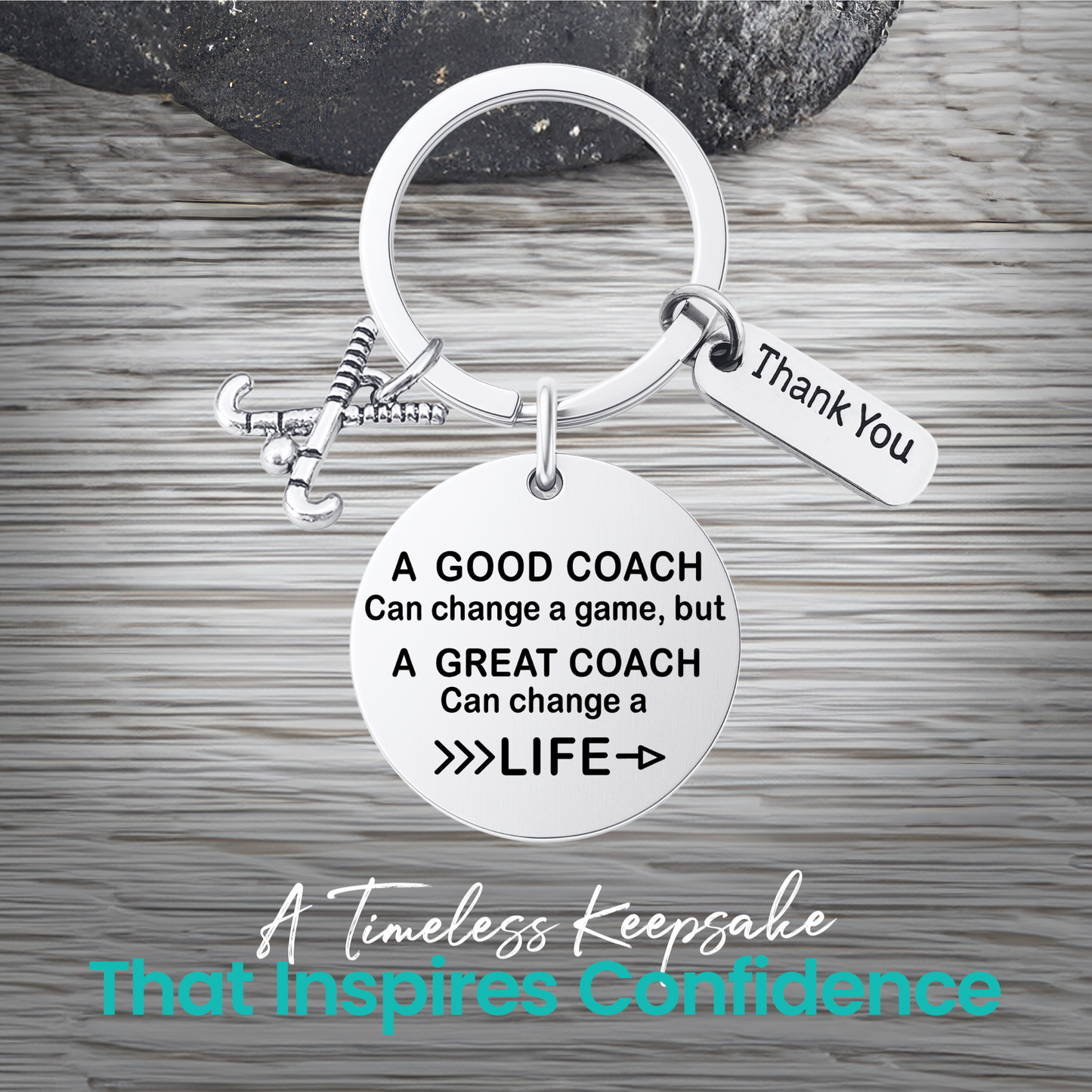 Silver coach keychain with engraved Great Coach Can Change a Life quote on rustic wooden surface