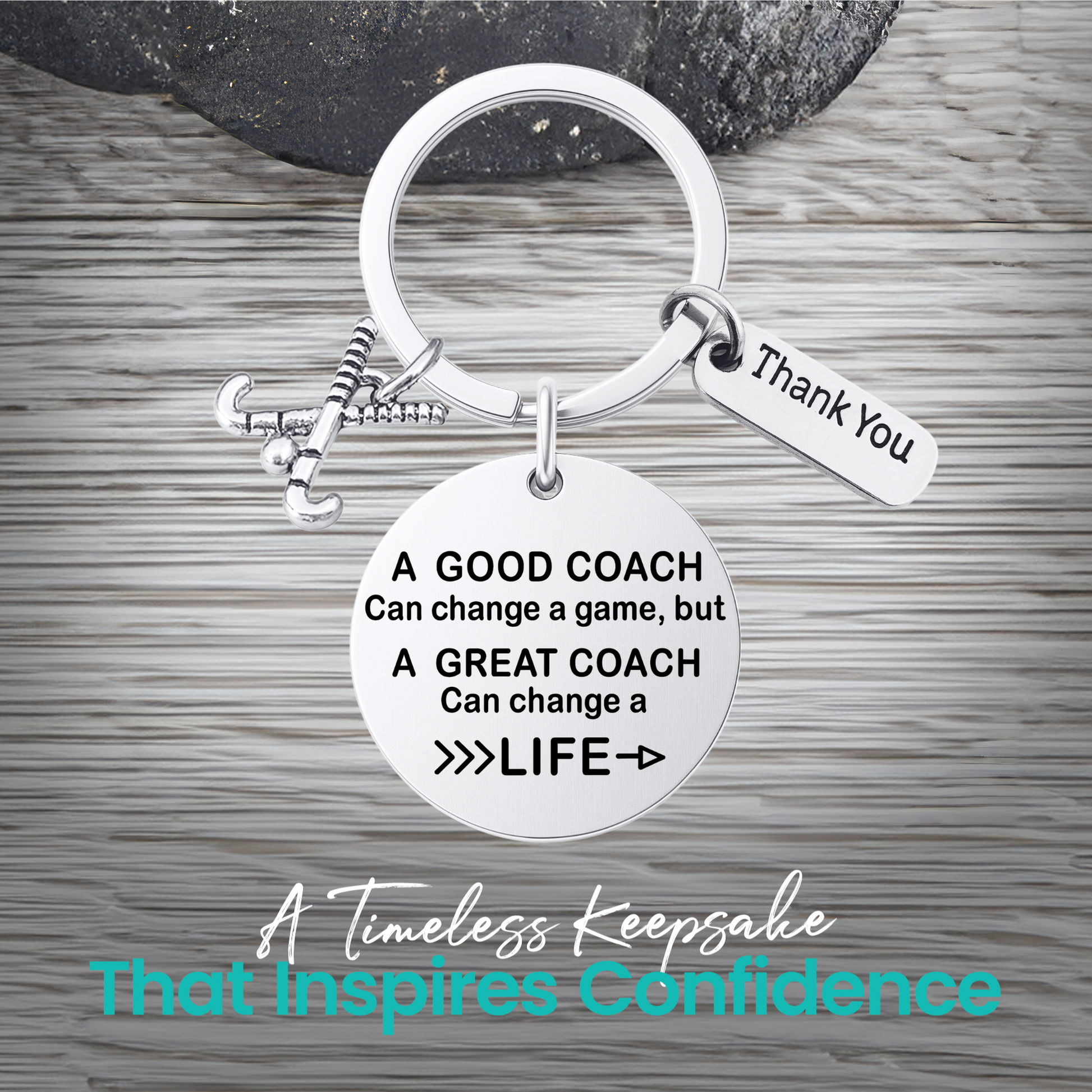 Silver coach keychain with engraved Great Coach Can Change a Life quote on rustic wooden surface