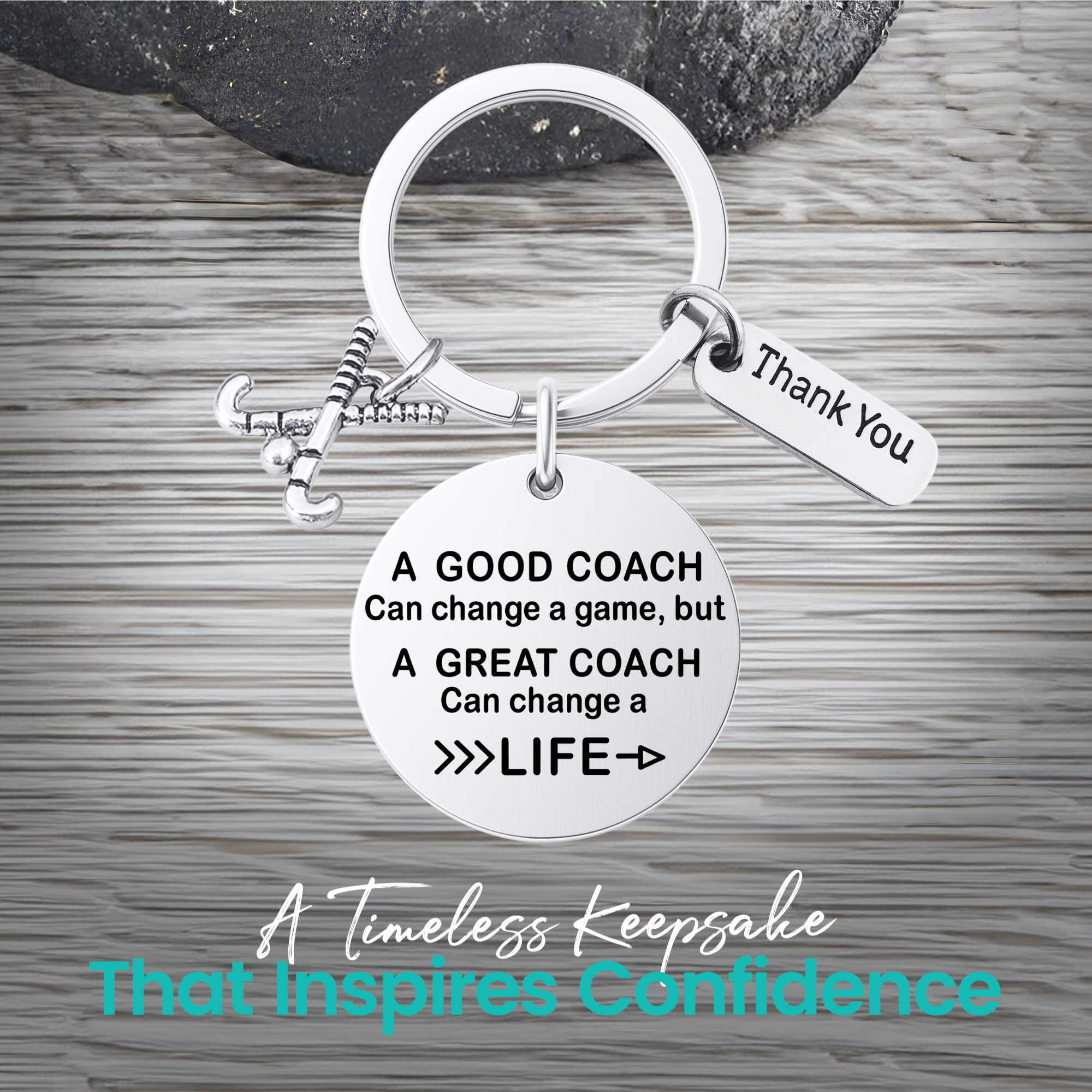 Silver coach keychain with engraved Great Coach Can Change a Life quote on rustic wooden surface