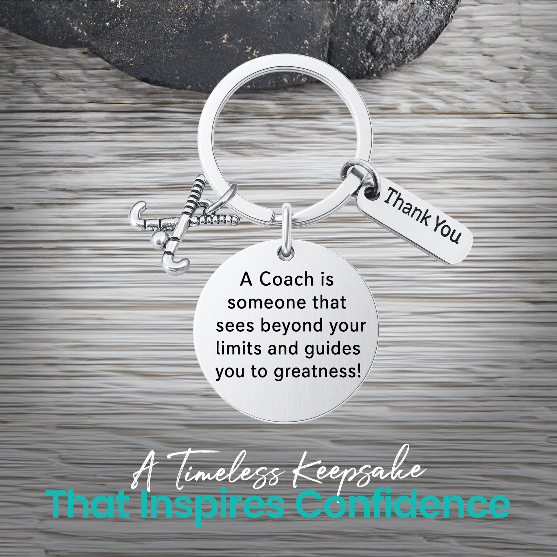 Silver coach keychain with engraved Sees Beyond Your Limits charm on rustic wood background