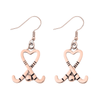 Rose gold heart-shaped field hockey stick dangle earrings with crossed sticks and ball design