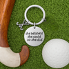 She Believed She Could So She Did field hockey keychain displayed on green artificial turf with hockey ball