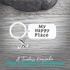 Close-up of field hockey keychain with My Happy Place engraving on rustic wood background