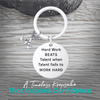 Silver field hockey keychain with engraved Work Hard Beats Talent charm on rustic wooden surface