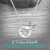 Silver She Believed She Could So She Did field hockey necklace on rustic wooden surface