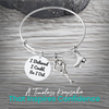 Figure skating bracelet with Believe in Yourself charm and ice skate charm displayed on rustic wood surface