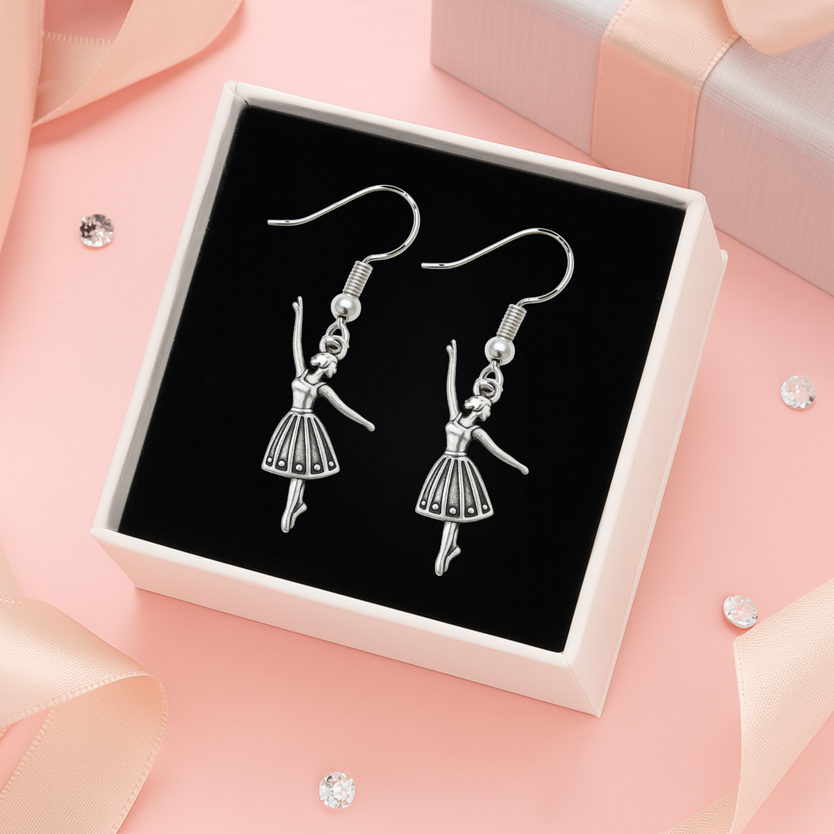Close-up of ballerina charm earrings displayed in a pink gift box, perfect for dancers