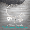 Expandable silver swim bracelet with motivational swim charms on rustic wood background