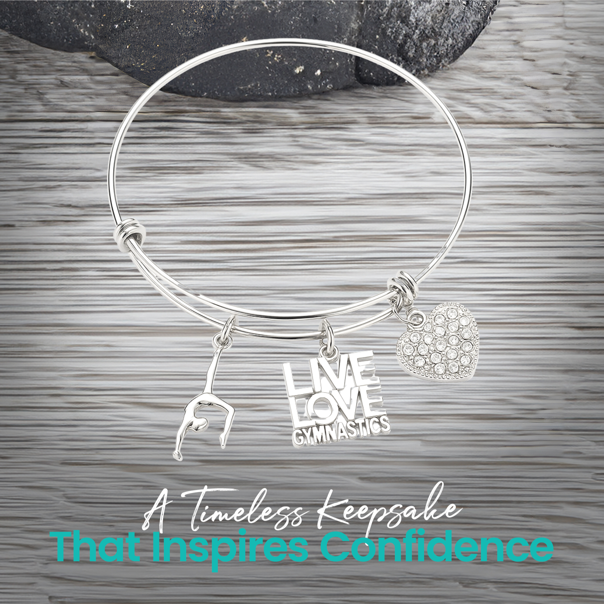 Expandable silver gymnastics bangle bracelet with charms displayed on rustic wooden surface