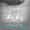 Silver horse head charm earrings displayed on rustic wood surface