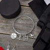 Hockey-themed charm bangle bracelet with silver charms and black velvet gift pouch
