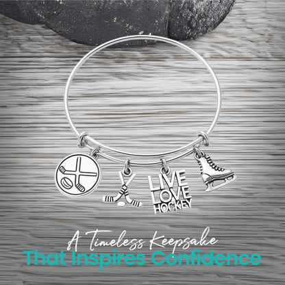 Adjustable silver hockey charm bracelet with puck, stick, and engraved charms