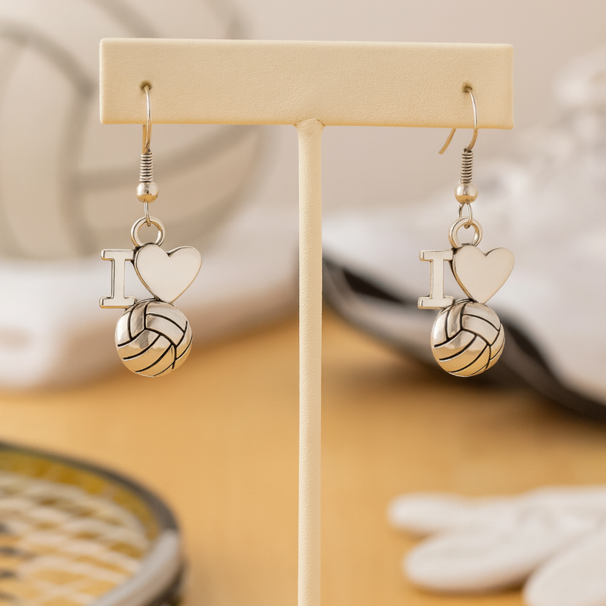 I Love Volleyball charm earrings hanging from jewelry display stand