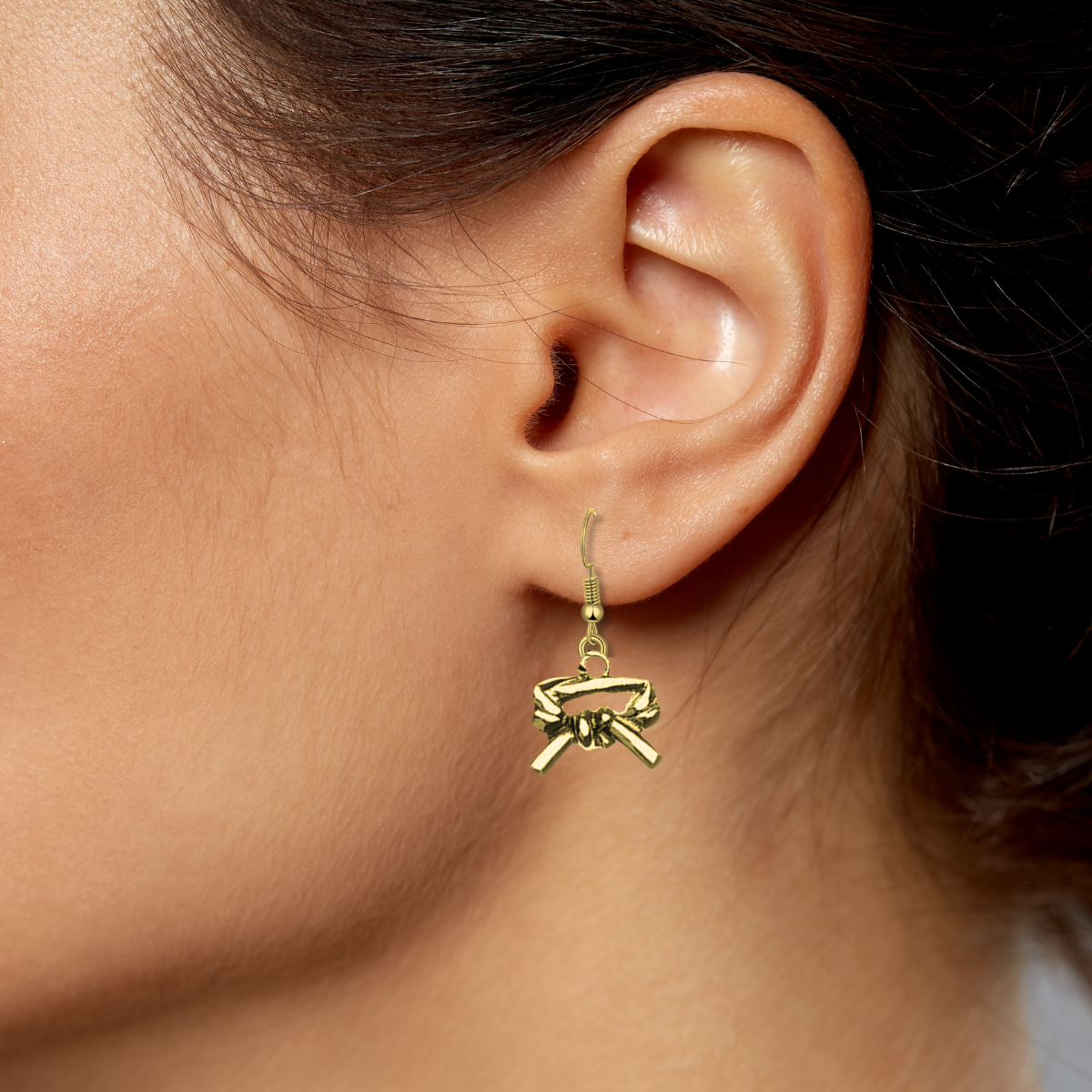 Lifestyle photo showing gold belt earrings worn by woman to demonstrate size and fit