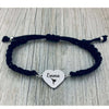 Close-up of engraved black bracelet laid on rustic wood background