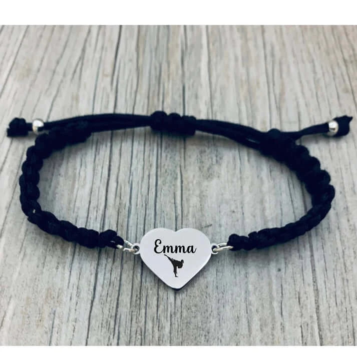 Close-up of engraved black bracelet laid on rustic wood background