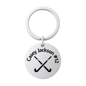 Stainless steel field hockey keychain engraved with name or number and crossed sticks design on white background