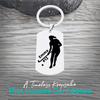 Engraved stainless steel field hockey player silhouette keychain with personalized text on rustic wood surface