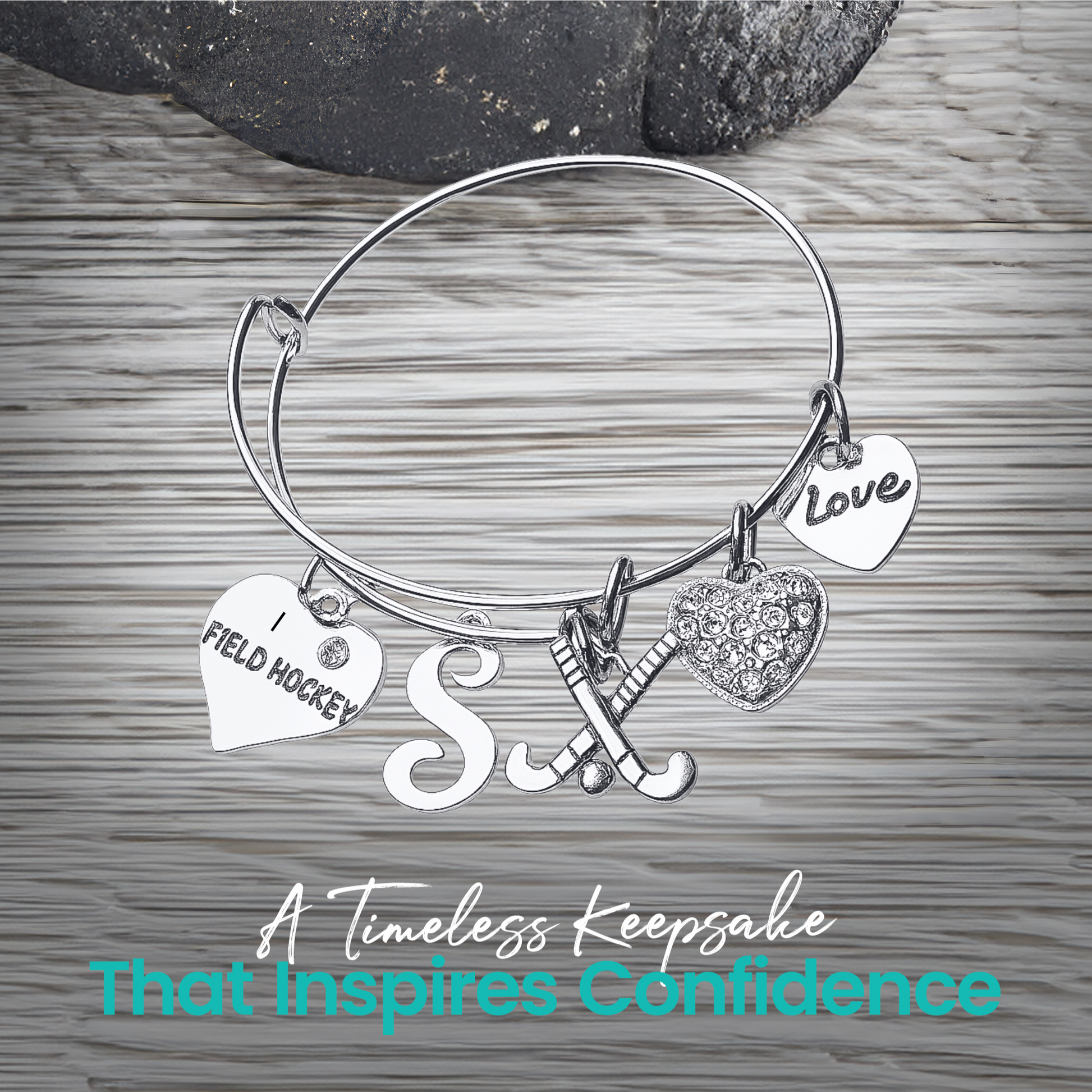 Adjustable silver field hockey bangle bracelet with charms displayed on wooden surface