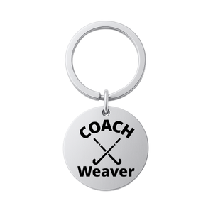Stainless steel personalized field hockey coach keychain engraved with COACH Weaver on white background