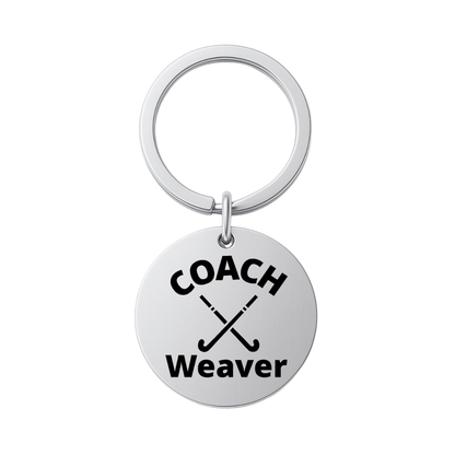 Stainless steel personalized field hockey coach keychain engraved with COACH Weaver on white background