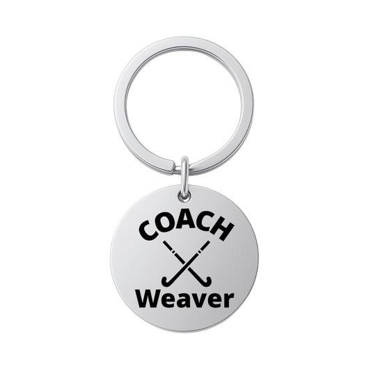 Stainless steel personalized field hockey coach keychain engraved with COACH Weaver on white background