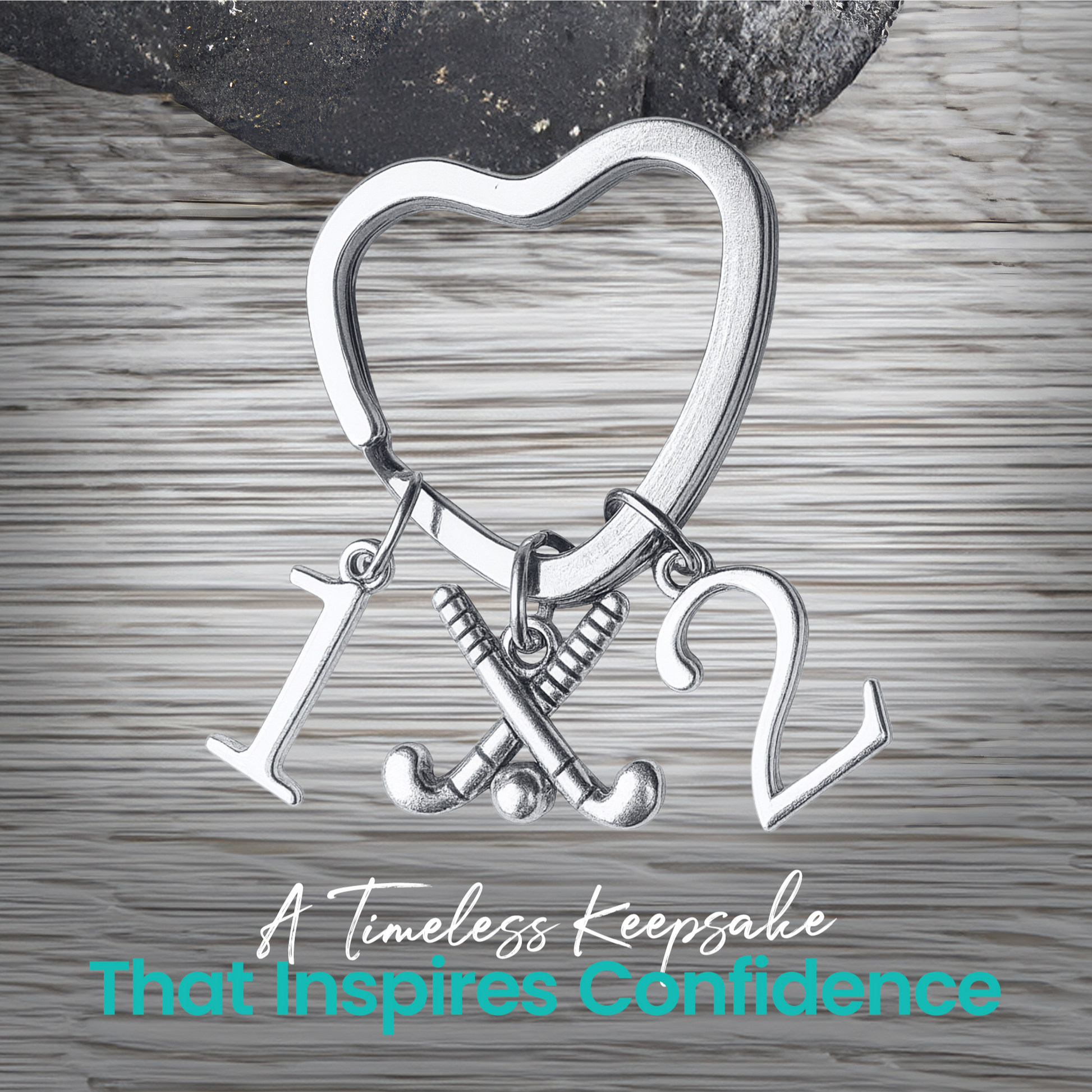 Silver heart-shaped field hockey keychain with crossed sticks and number charms on rustic wood