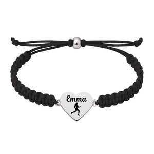 Lifestyle photo of navy rope bracelet with engraved running charm on wood surface